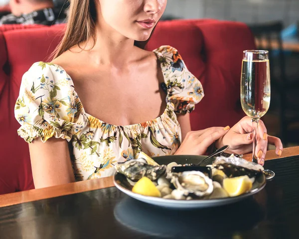 高価なレストランで美しいセクシーなブルネットの女性は牡蠣を食べてシャンパンを飲む レストランでコンセプト カキとシャンパンを食べ 飲みます ロイヤリティフリーのストック画像