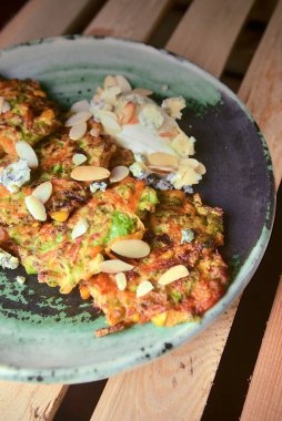 Kırsal ahşap arka planda eski seramik tabakta kızarmış patates krepleri. Ukrayna mutfağı kavramı.