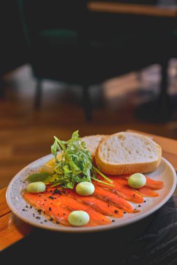 Siyah arkaplanlı ekmekle servis edilen somon balığı. Geçmişi bulanık, siyah masada servis edilmiş. Japon mutfağı kavramı.