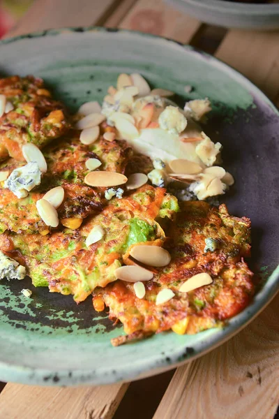 Kırsal ahşap arka planda eski seramik tabakta kızarmış patates krepleri. Ukrayna mutfağı kavramı.