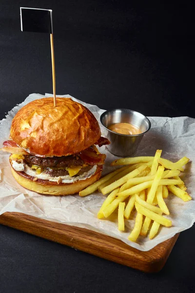 Świeży Smaczny Burger Czarnym Tle Podawany Sosem Frytkami Fast Food — Zdjęcie stockowe