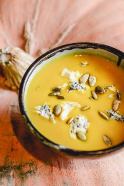 Siyah bir kasede balkabağı çorbası gerçek bir pompalama üzerine. Sonbahar menüsü konsepti, Ukrayna mutfağı. Konsepti değiştir, yaratıcı fotoğraf.
