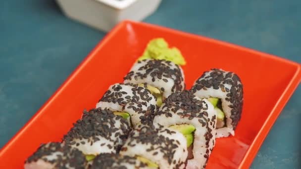 日本の伝統的な食のクローズアップ 寿司セットは 新鮮な寿司ロールを調理し 美しい赤いプレートで提供しています 寿司セットプレゼンテーション — ストック動画