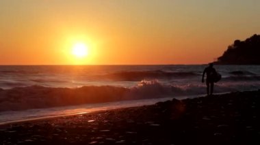Sörfçü Gün Batımında Kıyı boyunca Walks, Gün Batımında Sahilde Sörfçü Yürüyüş