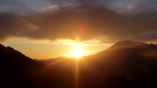 Heldere zonsondergang in de bergen, donkere wolken, de lichten van een zon — Stockvideo