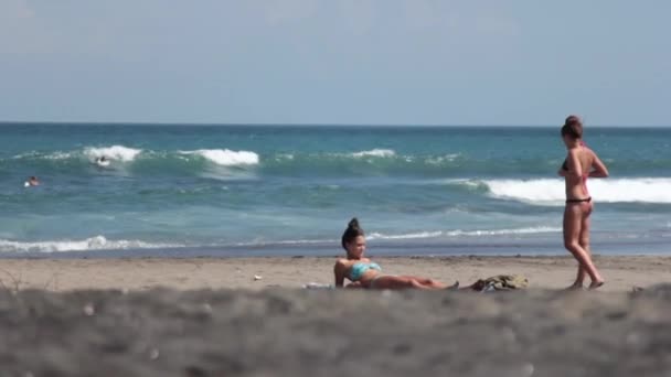 Mädchen sonnen sich am Strand — Stockvideo