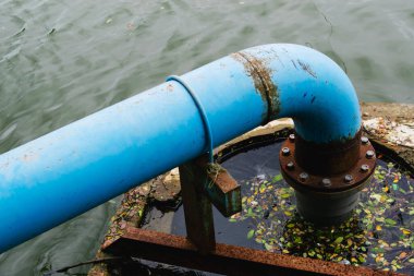 Nehirdeki eski paslı metal borular.