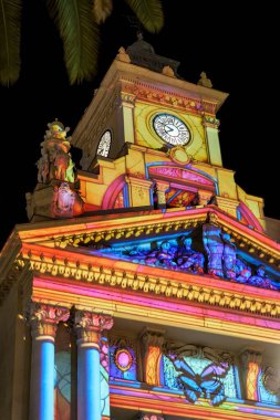 Malaga, İspanya; 29 Aralık 2025: Malaga Belediye Binası gece renkli Noel ışığı projeksiyonlarıyla aydınlatıldı. Güney İspanya 'da tarihi mimarinin altını çizen şenlikli bayram dekorasyonu