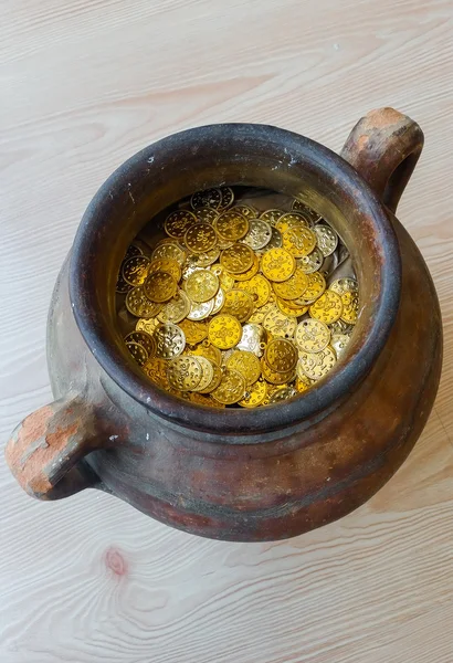 Fake gold and silver coins in earthenware jar