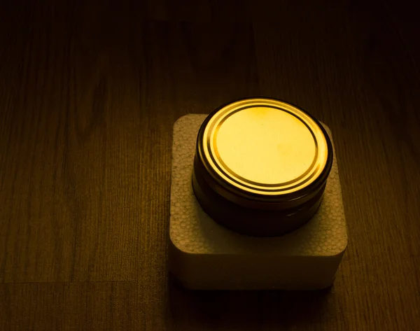 Tampa do frasco iluminada em fundo escuro — Fotografia de Stock