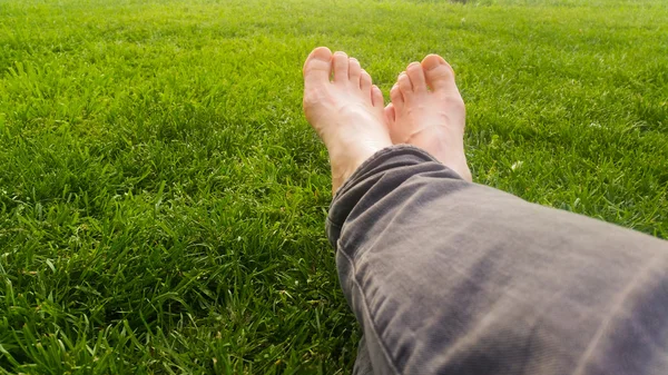 Pieds nus sur l'herbe verte sous la lumière du soleil — Photo