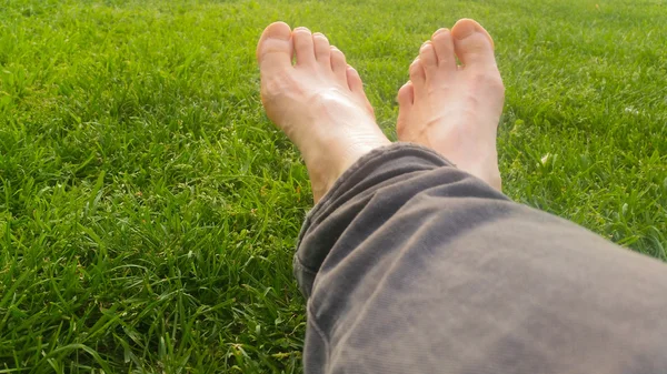 Босонога на зеленій траві під сонячним світлом — стокове фото