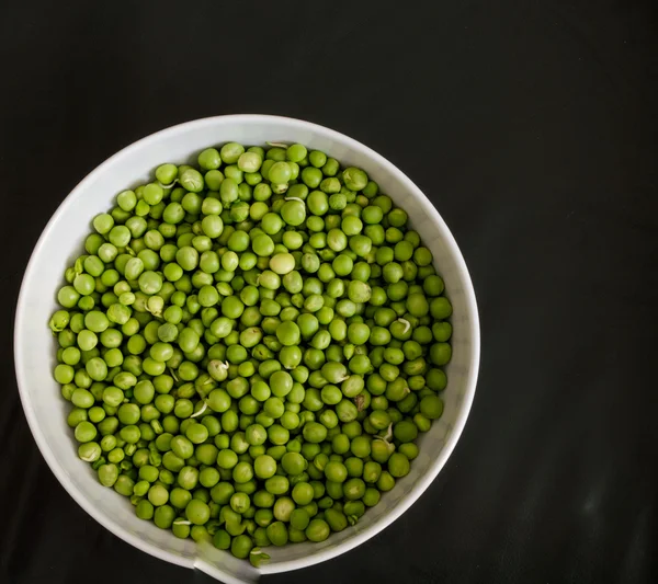 Guisantes verdes en un tazón blanco — Foto de Stock