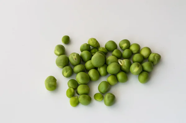 Ervilhas verdes em um fundo branco — Fotografia de Stock