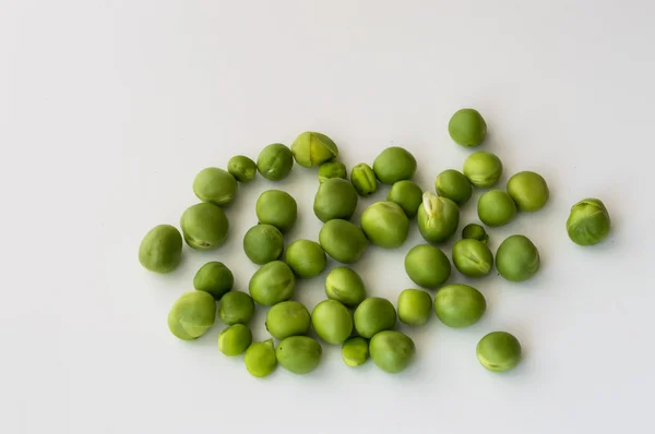 Grüne Erbsen auf weißem Hintergrund — Stockfoto