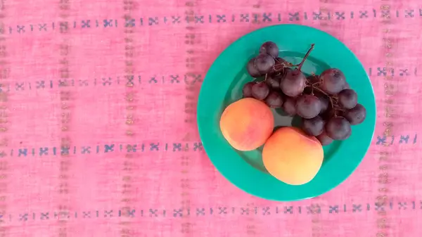 Draufsicht auf Trauben mit Aprikosen im Teller — Stockfoto