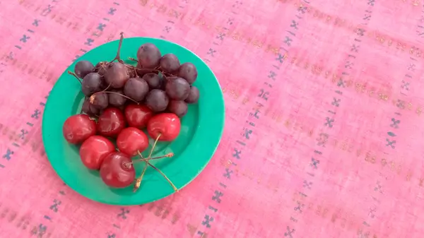 Cerises et raisins dans une assiette — Photo