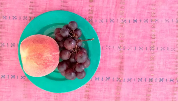 Draufsicht auf Trauben mit Pfirsich im Teller — Stockfoto