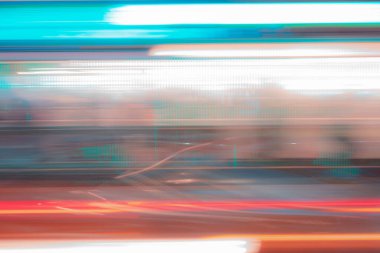 Uzun pozlama, mavi ışık, fotoğraf, dalgalar ve çizgiler siyah arka plana karşı. Hızlı giden bir trenin penceresinden şehir ışıklarının görüntüsü.