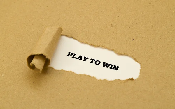 Jogar para ganhar mensagem escrita em papel rasgado . — Fotografia de Stock