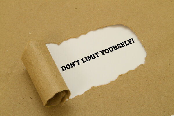 DO NOT LIMIT YOURSELF message written under torn paper.