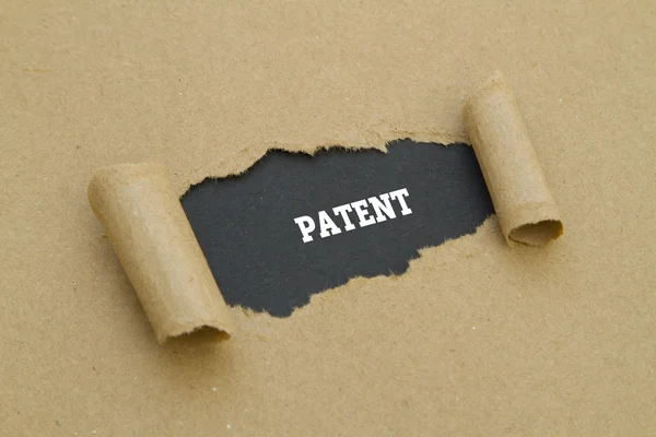 Patent woord geschreven onder gescheurd papier. — Stockfoto