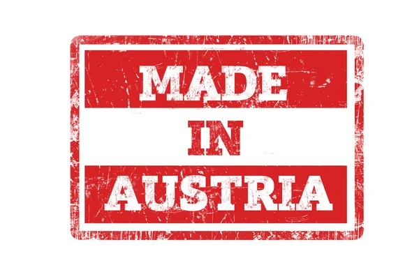 MADE IN AUSTRIA word written on red rubber stamp and flag with grunge edges. — Stock Photo, Image