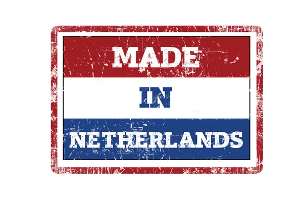 MADE IN NETHERLANDS word written on red rubber stamp and flag with grunge edges. — Stock Photo, Image