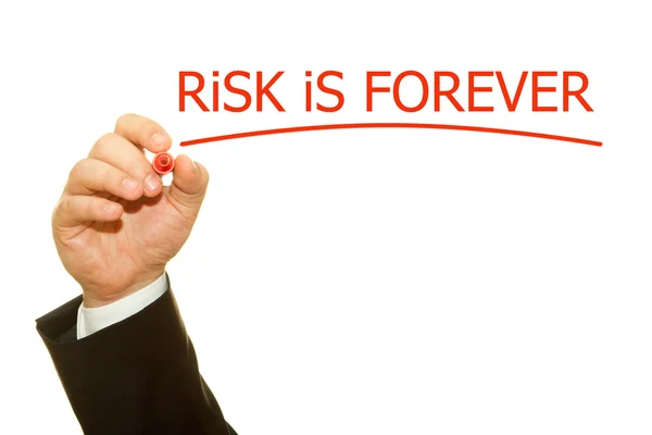 Businessman hand writing Risk is forever on a transparent wipe board — Stock Photo, Image