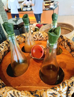 Sağlık ve refah için geleneksel Java bitkisel ilaçları (jamu gendong). Bambu kapları ve muz yaprağı kaplamalı şişelerde sanatsal ve cazip bir şekilde sunulduğu için tüketicileri cezbediyor. Otellerde kahvaltıyla servis edilir..