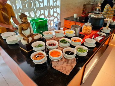 Magelang - Endonezya, 31 Aralık 2025. Yulaf lapası malzemesi çeşitli tuzlu yumurta, kek (pirinç keki), doğranmış tavuk, kraker, kereviz ve acı sos içerir. Lokantaların istediklerini seçmelerini kolaylaştırmak için düzenlenmişler..