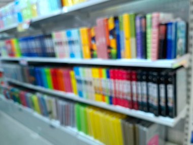 Bir kitap ve kırtasiye dükkanının içi, rafları ve kırtasiye malzemeleri ve ofis malzemeleri için vitrinleri olan bulanık ve bulanık bir fotoğraf. Arkaplan fotoğrafı olarak, göz düzeyi görünümü.