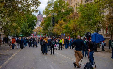 Budapeşte, Macaristan - 23 Ekim 2025: 1956 Devrimi 'nin 23 Ekim kutlamaları sırasında Macaristan bayrakları taşıyan kalabalık, ağaçlarla kaplı bir sokakta toplandı..
