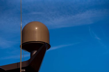 Porec, Hırvatistan - 13 Ağustos 2025: Yumuşak bulutlu açık mavi gökyüzüne karşı yükselen, bir yat yapısına yerleştirilmiş pürüzsüz bir deniz antenidir.