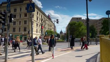 Budapeşte, Macaristan - 17 Mayıs 2025: Meşgul bir Budapeşte yaya geçidi tarihi sarı binalar ve uzak mesafedeki ikonik parlamento kubbesi yakınlarından geçen birçok yaya geçidi.