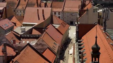 Maribor, Slovenya - 9 Ağustos 2025: Havadan bakıldığında, Maribor 'un tarihi merkezinin yoğun, terasotta döşeli çatılarının parlak, berrak mavi gökyüzü altındaki kayan tepelere doğru uzandığı görülüyor.