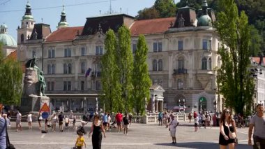 Ljubljana, Slovenya - 10 Ağustos 2025: Manzaralı bir manzara Ljubljanica Nehri 'nin Ljubljana' nın tarihi merkezinde dolanıp, yemyeşil setler ve zarif mimariyle kaplı olduğunu gösteriyor.