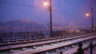Budapeşte, Macaristan - 6 Ocak 2026: Karla kaplı tramvay hatları Budapeşte 'deki Tuna seti boyunca uzanan ve karla kaplı Buda Şatosu ve Zincir Köprüsü' nü geniş bir açıdan görme olanağı sunuyor..