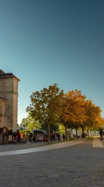 Alba Iulia, Romanya - 20 Ekim 2024: Str. Mihai Viteazul sokak manzarası. Soldaki Aziz Michael Katedrali. Zaman geçişi, kayma geçişi, dikey yönelim. Açık gökyüzü güneşli gün.