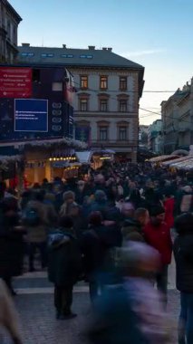 Budapeşte, Macaristan - 23 Kasım 2024: St Stephens Bazilikası 'nda Noel Pazarı. Kilisenin büyük kubbesinin altında sıcak şarap tezgahları ve el yapımı hediyeler parlıyor. Zaman kayması, kayma geçişi, dikey.