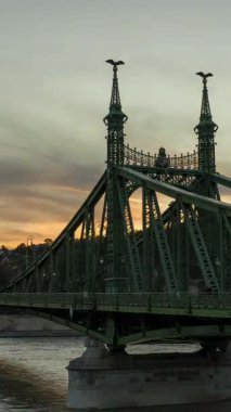 Budapeşte, Macaristan - 14 Ekim 2024: Alacakaranlık 'tan Geceye: Budapeşte' de Özgürlük Köprüsü üzerindeki Hiperlapse Büyüsü, dikey yönelim, geçiş dönemi yakınlaştır.