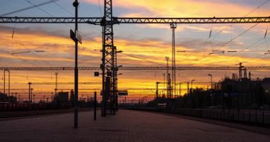Szekesfehervar, Macaristan - 2 Kasım 2024: Szekesfehervar Tren İstasyonu 'nda Orange Sunset. Zaman ayarlı, geçişi yakınlaştır.