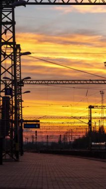 Szekesfehervar, Macaristan - 2 Kasım 2024: Szekesfehervar Tren İstasyonu 'nda Orange Sunset. Zaman aşımı, uzaklaşma geçişi, dikey yönelim.