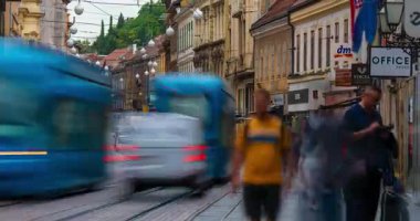 Zagreb, Hırvatistan - 23 Ağustos 2025: Zagreb 'deki Ilica Caddesi' nin zaman çizelgesi, yayaların ve yerel mağazalar ve kafelerle dolu tarihi cephelerin yanından geçen mavi tramvayların yer aldığı bir zaman çizelgesi.