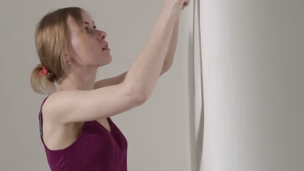 Молодая девушка оштукатуривает стену лопатой в своем доме, тень — стоковое видео