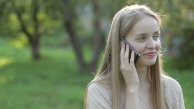 Güzel bir kadın telefonda konuşuyor.