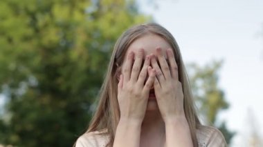 Genç kız yüzünü iki eliyle kapsar