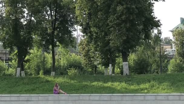 Menina no parque escreve em seu diário pessoal — Vídeo de Stock