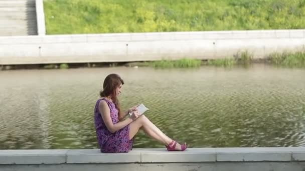 Young girl writing by the Riverside — Stock Video