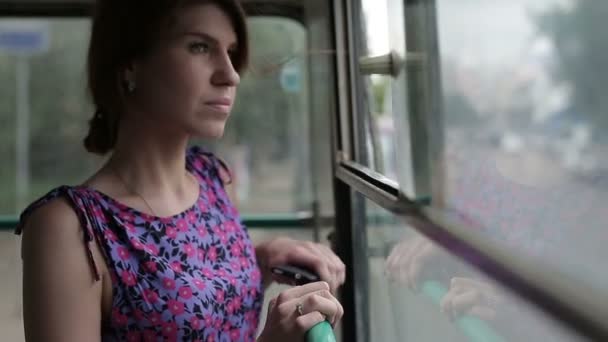 Женщина едет в автобусе и смотрит в окно — стоковое видео